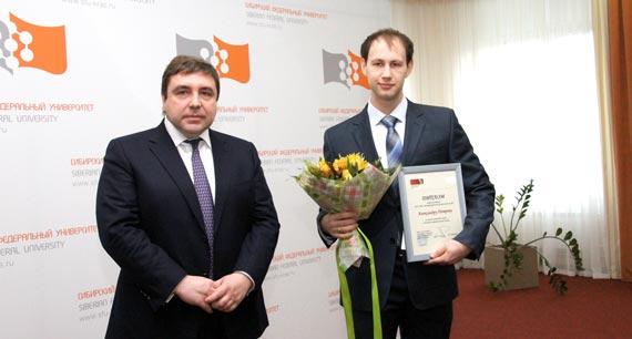 Первый заместитель председателя правления банка МФК В. Шабайкин вручает Александру заслуженную награду